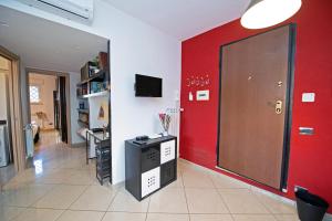 una habitación con una pared roja y una puerta roja en B&Bea sweet home Aurelia, en Roma