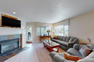 sala de estar con sofá y chimenea en Mountain Lake Getaway (B101), en Twin Beaches