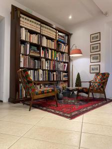 un soggiorno con libreria piena di libri di Hotel Bernardino a Lucca