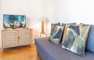 a living room with a blue couch and a tv at Abrotea Apartments in Lagos