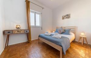 a bedroom with a bed with blue sheets and a mirror at Abrotea Apartments in Lagos