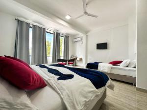 1 dormitorio con 2 camas y ventilador de techo en Brisa Fresca, en Thoddoo