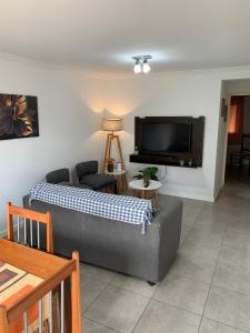 a living room with a couch and a flat screen tv at Lumiere Apartments - Confortable Departamento en Complejo Residencial in Mendoza