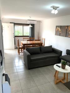 - un salon avec un canapé et une table dans l'établissement Lumiere Apartments - Confortable Departamento en Complejo Residencial, à Mendoza