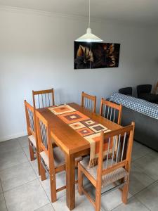 einem hölzernen Esstisch mit Stühlen und einem Sofa in der Unterkunft Lumiere Apartments - Confortable Departamento en Complejo Residencial in Mendoza