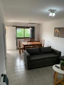 uma sala de estar com um sofá e uma mesa em Lumiere Apartments - Confortable Departamento en Complejo Residencial em Mendoza