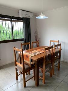 a dining room table with chairs and a wooden table at Lumiere Apartments - Confortable Departamento en Complejo Residencial in Mendoza