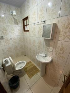 um banheiro com vaso sanitário e pia em Pouso das Folhas em Tiradentes