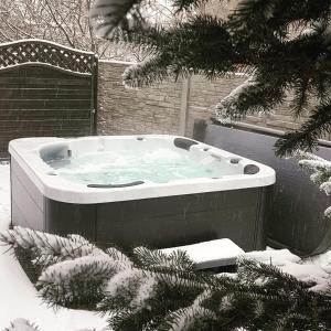 a hot tub in a yard covered in snow at Pueblo Apartamenty in Stegna