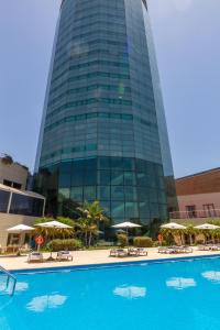a tall building with a swimming pool in front of a building at Quinto Centenario Hotel in Cordoba