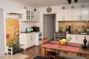 a kitchen with a table with a bowl of fruit on it at Ferienwohnung Winklworld inklusive aktivCARD in Sankt Englmar