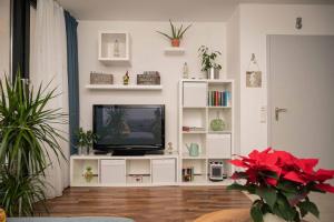 uma sala de estar com televisão num centro de entretenimento branco em Ferienwohnung Winklworld inklusive aktivCARD em Sankt Englmar