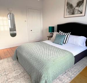 ein Schlafzimmer mit einem großen Bett mit einer grünen Bettdecke in der Unterkunft 1 Bed / 1 Sofa Bed 'Scandi' Style Ground Floor Apartment in Yeovil