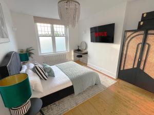 a bedroom with a bed and a tv on the wall at 1 Bed / 1 Sofa Bed 'Scandi' Style Ground Floor Apartment in Yeovil