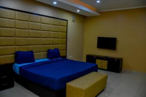 a bedroom with a blue bed and a tv at Beautiful Town House in Lagos