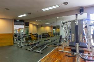 a gym with a lot of tread machines and mirrors at Quinto Centenario Hotel in Cordoba