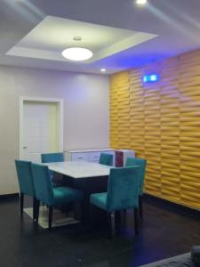 a conference room with a table and blue chairs at Beautiful Town House in Lagos