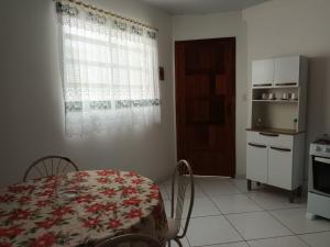 uma cozinha com mesa e cadeiras e uma janela em Apartamento aconchegante 12 min da praia em Cabo Frio