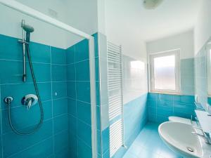 baño azul con ducha y lavamanos en Homiday - Residence K2, en Pineto