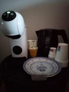 a coffee maker and a plate on a table with a coffee pot at La Giara B&B in San Demetrio Corone
