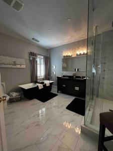 a bathroom with a shower and a sink and a tub at Relaxing modern home with In-ground pool in Burlington
