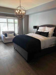 Un dormitorio con una cama grande y una lámpara de araña. en Relaxing modern home with In-ground pool, en Burlington