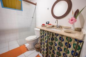 een badkamer met een wastafel, een toilet en een spiegel bij Pousada Canoa Nativa in Ilha de Boipeba