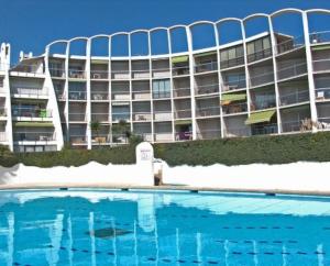ein Hotel mit einem Pool vor einem Gebäude in der Unterkunft *Les Dunes, 50 m des plages, clim, Netflix,4 pers* in La Grande-Motte