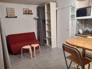ein Wohnzimmer mit einem roten Sofa und einem Tisch in der Unterkunft *Les Dunes, 50 m des plages, clim, Netflix,4 pers* in La Grande-Motte