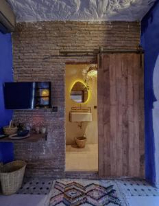 a bathroom with a brick wall and a sliding door at Casa Amina in Chefchaouene