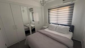 a bedroom with a bed with white sheets and a mirror at Nicosia’s pearl in North Nicosia
