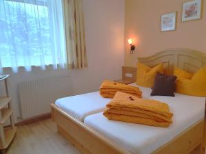 a bedroom with two beds with yellow pillows and a window at Ferienheim Gasteig in Neustift im Stubaital
