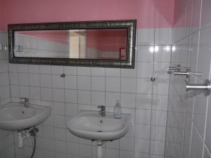 a white bathroom with a sink and a mirror at Familienurlaub auf dem Land - haustierfreundlich - 10 Minuten von Templin in Milmersdorf