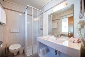 a bathroom with a sink and a shower and a toilet at Garni Hotel Max in Santa Cristina Gherdëina