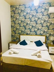 a bedroom with a bed with a blue and white wallpaper at Nana's House in Batumi