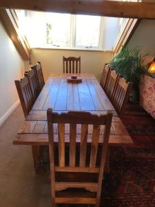 una mesa de madera en una habitación con sillas alrededor en Large Ingleton Apartment, Yorkshire Dales, Three Peaks en Ingleton 