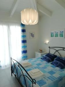 Schlafzimmer mit einem Bett und einem Kronleuchter in der Unterkunft Villa Agata in Budoni