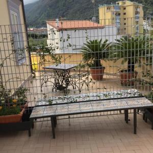 um banco sentado em cima de uma varanda com plantas em Sorrento Penthouse Suites em Sant'Agnello