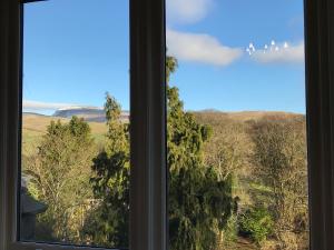 una ventana con vistas a un campo y a los árboles en Large Ingleton Apartment, Yorkshire Dales, Three Peaks en Ingleton 