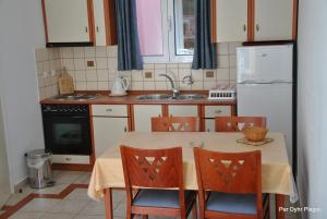 a kitchen with a table and chairs and a sink at MIRSINI HOTEL in Plomari