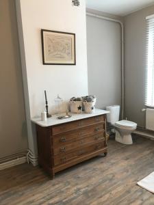 a bathroom with a wooden dresser and a toilet at Les colombages in Dinant