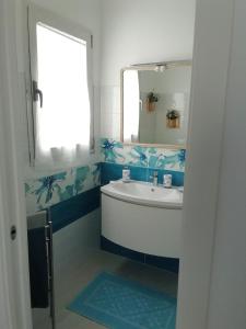 ein Bad mit einem Waschbecken und einem Spiegel in der Unterkunft Villa Agata in Budoni