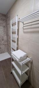 una toalla blanca sentada en un estante del baño en Atrium Toledo, en Toledo