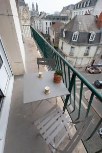 stół na balkonie z dwoma filiżankami kawy w obiekcie Appartement LE JULES FAVRE w Tours