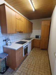 cocina con armarios de madera y horno de fogón blanco en Ferienwohnung Linden 87, en Willich