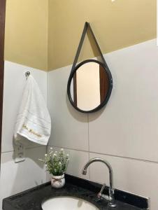 baño con lavabo y espejo en la pared en POUSADA SOLAR DOS MOREIRAS, en Guajirú