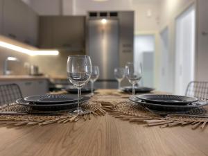 een tafel met borden en wijnglazen erop bij Anneta’s home in Athene