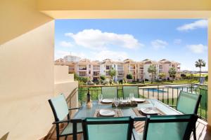un tavolo da pranzo e sedie sul balcone di un appartamento di Columbus Beach Apartment a Quarteira