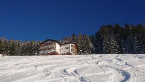 ein Gebäude auf einem schneebedeckten Hang in der Unterkunft Hotel Hahnbaum in St. Johann im Pongau