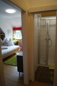 łazienka z prysznicem oraz sypialnia z łóżkiem w obiekcie Die Bäckerei w mieście Maria Rain